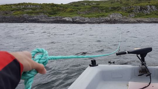 Précédemment, nous sommes allé frapper une amarre à la côte. Nous la ramenons au bateau pour la fixer et la régler.