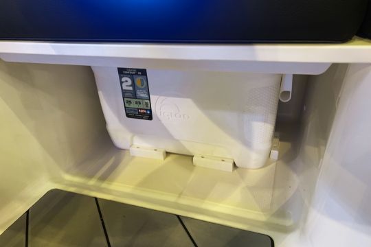 Un emplacement pour la glacière positionnée sous une des assises à bâbord