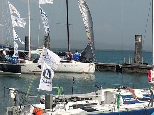 Ludovic Gérard, à l'eau, frotte la coque de son JPK 10.80